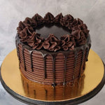 A forest Fudge chocolate cake with chocolate frosting and decorative chocolate whipped cream rosettes on top, as a sweet treat by Cake Gurus Ruaka Nairobi with deliveries in Nairobi and its environs