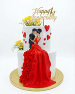 Anniversary cake with a couple in a red dress and 'Happy 1st Anniversary' topper.