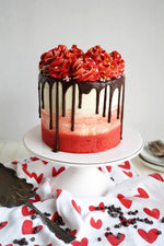 A chocolate red cake with creamy frosting, decorated with red roses and a chocolate drip down the sides, as a sweet treat by Cake Gurus Ruaka Nairobi with deliveries in Nairobi and its environs