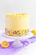 A Coconut Lemon Cake with yellow frosting and decorative sprinkles with lemon slices as a sweet treat by Cake Gurus Ruaka Nairobi with deliveries in Nairobi and its environs