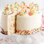 A Funfetti Cake with multiple layers, covered in white frosting and decorated with colorful sprinkles,  as a sweet treat by Cake Gurus Ruaka Nairobi with deliveries in Nairobi and its environs.