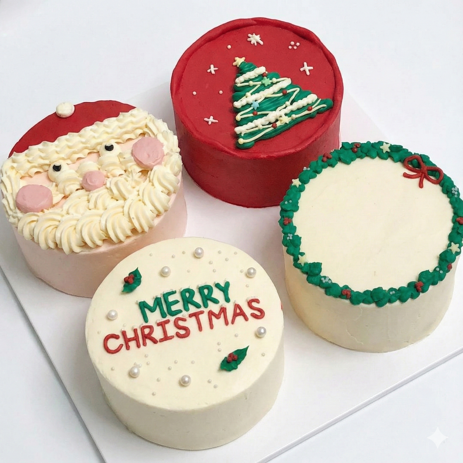 Four Christmas-themed cakes on a white surface