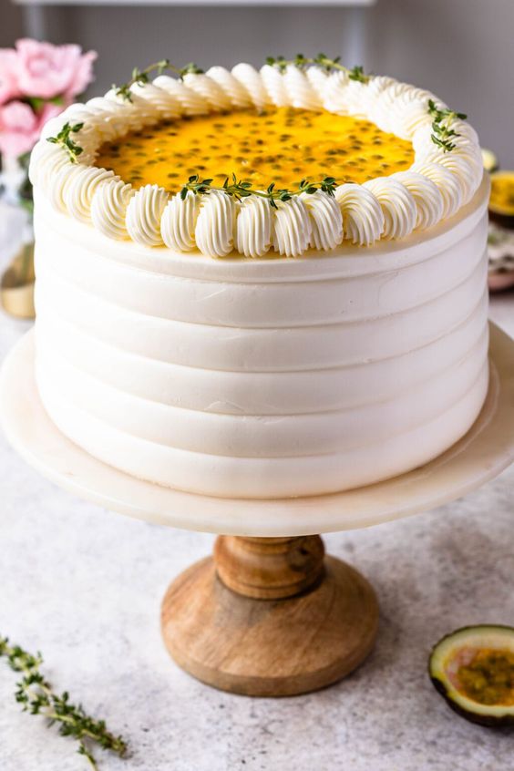 A multi-layered Passion Forest Bento Cake with white frosting and passion fruit filling, garnished with a passion fruit slice and green leaves on top,  as a sweet treat by Cake Gurus Ruaka Nairobi with deliveries in Nairobi and its environs.