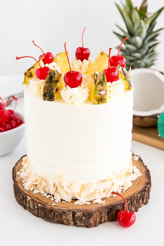 A Piña Colada Cake decorated with pineapple pieces and cherries,  as a sweet treat by Cake Gurus Ruaka Nairobi with deliveries in Nairobi and its environs.