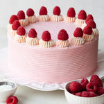 A round raspberry cake with pink frosting, topped with fresh raspberries,  as a sweet treat by Cake Gurus Ruaka Nairobi with deliveries.in Nairobi and its environs.