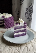 A slice of red velvet cake with white frosting on a plate,  as a sweet treat by Cake Gurus Ruaka Nairobi with deliveries in Nairobi and its environs.