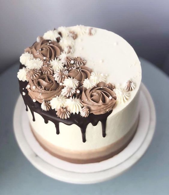 A vanilla cake with white and chocolate brown icing, decorated with floral-like icing designs on top  as a sweet treat by Cake Gurus Ruaka Nairobi with deliveries in Nairobi and its environs.