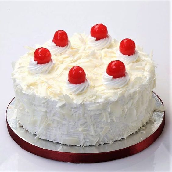 A white forest cake with light vanilla sponge and white chocolate mousse, garnished with cherries on top,  as a sweet treat by Cake Gurus Ruaka Nairobi with deliveries in Nairobi and its environs.