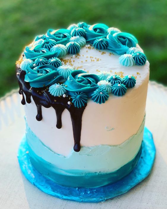 A butterscotch cake with blue layers and blue frosting, topped with a chocolate drizzle and gold sprinkles  as a sweet treat by Cake Gurus Ruaka Nairobi with deliveries in Nairobi and its environs.