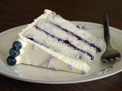 A slice of blueberry cake with white frosting and blueberry filling,  as a sweet treat by Cake Gurus Ruaka Nairobi with deliveries in Nairobi and its environs.