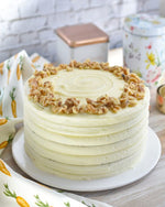 A carrot nut cake with cream cheese frosting and topped with chopped nuts,  as a sweet treat by Cake Gurus Ruaka Nairobi with deliveries in Nairobi and its environs.