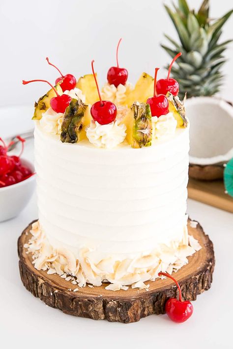 A Carrot Pineapple Cake with white frosting, decorated with pineapple pieces and cherries,  as a sweet treat by Cake Gurus Ruaka Nairobi with deliveries in Nairobi and its environs.