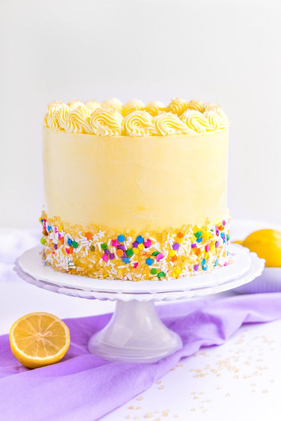 A Coconut Lemon Cake with yellow frosting and decorative sprinkles with lemon slices  as a sweet treat by Cake Gurus Ruaka Nairobi with deliveries in Nairobi and its environs