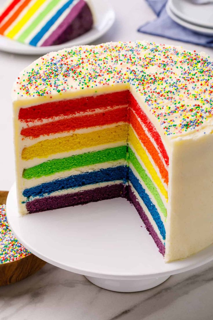 A colorful Rainbow Cake with multiple layers of different colors, topped with sprinkles,  as a sweet treat by Cake Gurus Ruaka Nairobi with deliveries in Nairobi and its environs.